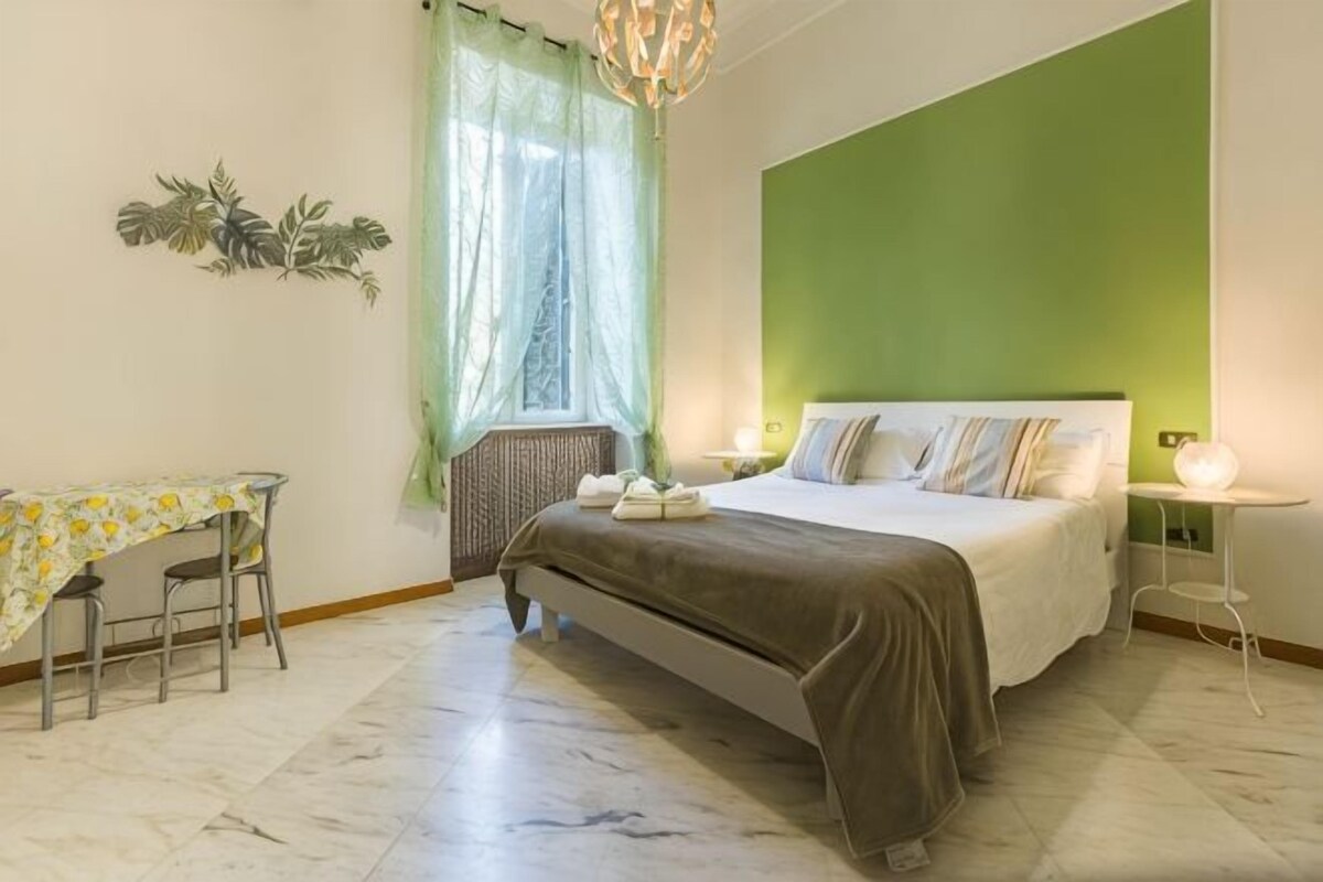 A bedroom with a bed, a desk, and a chair.