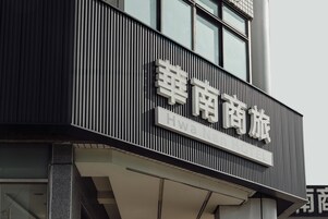 Un letrero de hotel con caracteres chinos y el texto en inglés 'Hwa Nan Hotel'.