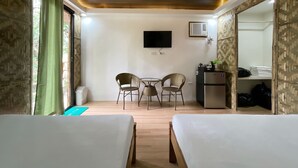 A hotel room with two beds, a small table with chairs, a TV, and a kitchenette. - Caliraya Ecoville Recreation and Farm Resort (Cavinti)
