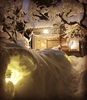 A snow-covered outdoor area with a building in the background. - NEMARU Stay&Discovery - Hostel (Nagaoka)