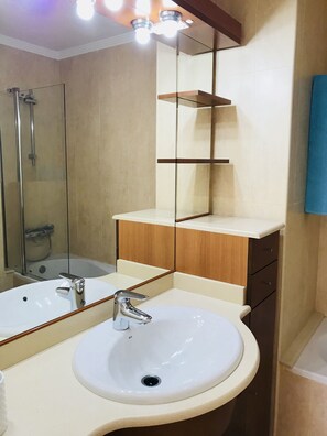 A bathroom with a white sink, a mirror, and a shower enclosure. - La Casa Canaria (Mogan)
