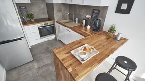 Eine moderne Küche mit einer Holztheke, Edelstahlgeräten und einer Kaffeestation.