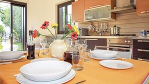 A dining table set with plates, glasses, and a vase with flowers.
