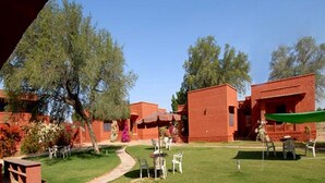 Un patio con edificios de ladrillo, mobiliario exterior y plantas.