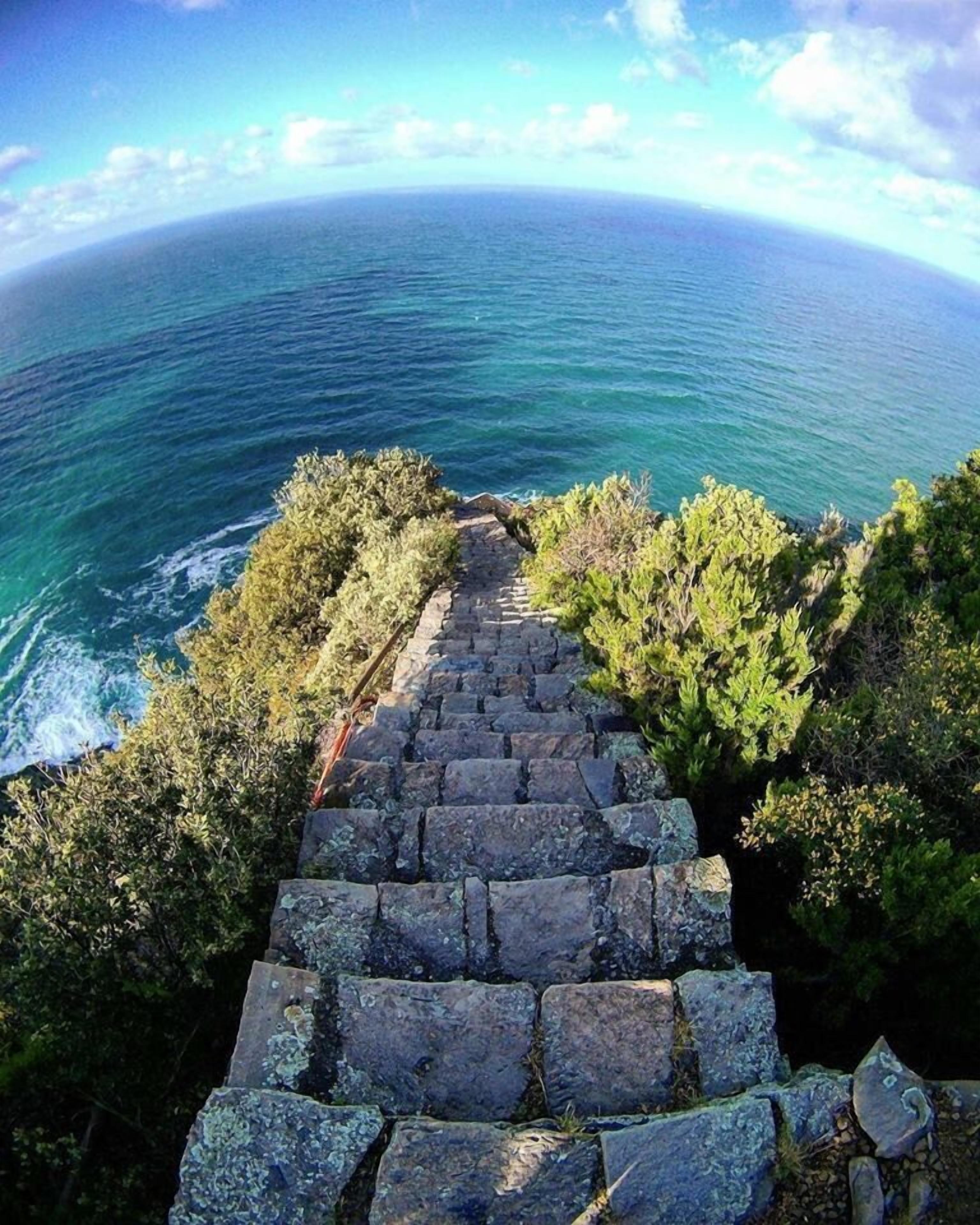 A stone staircase leading to a viewpoint overlooking a body of water.