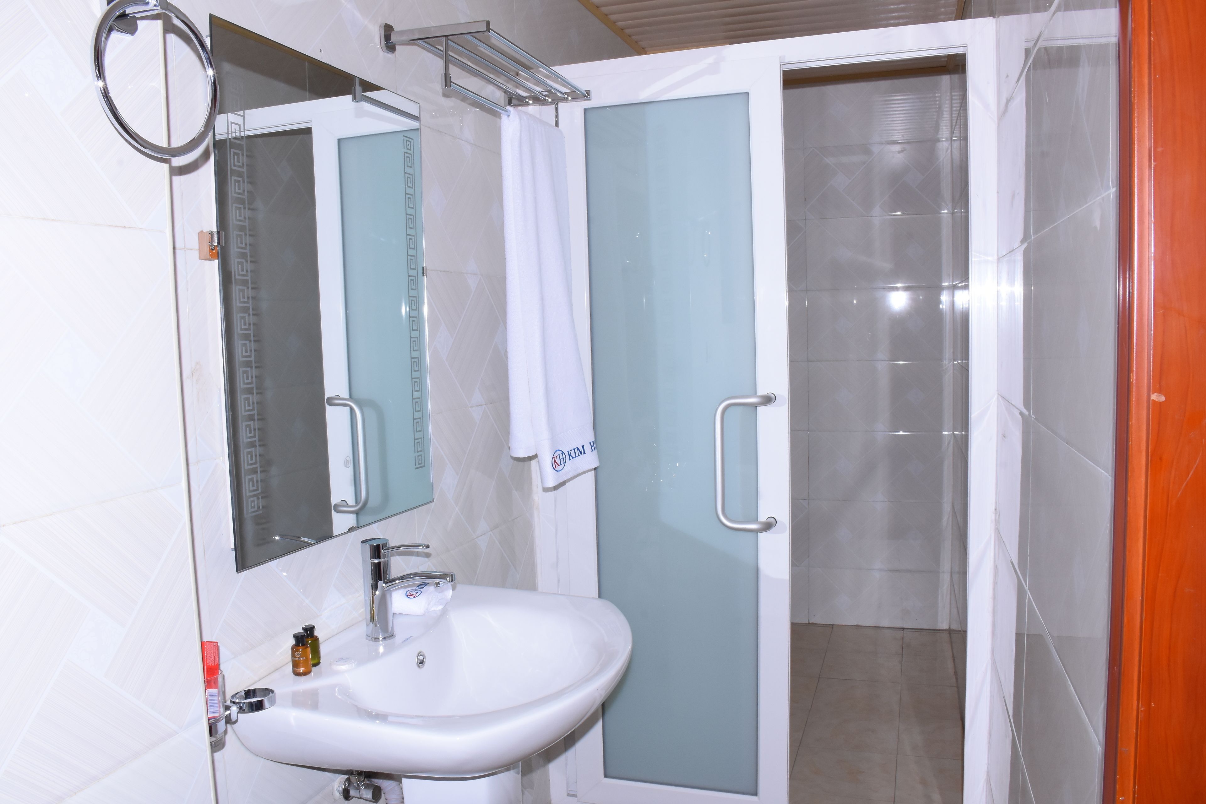 A bathroom with a white sink, a mirror, and a glass shower enclosure.
