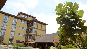 A multi-story building with a pool and outdoor seating area.