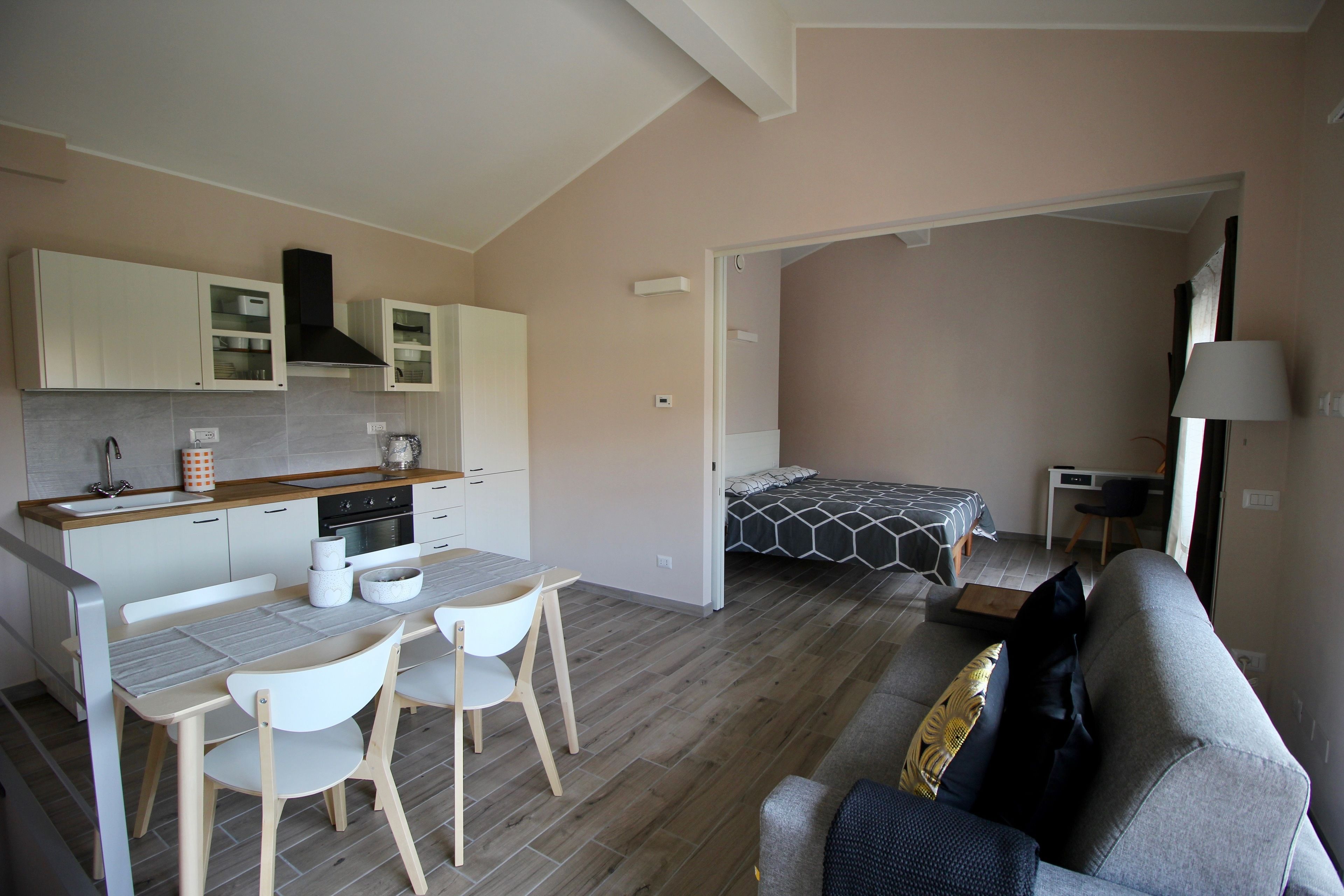 Un espacio habitable compacto con kitchenette, comedor y dormitorio.