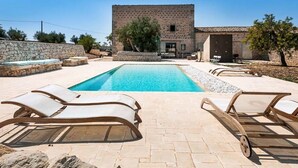 Una piscina al aire libre de temporada, sillones reclinables de piscina