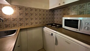 Una cocina compacta equipada con microondas, lavavajillas y estufa.