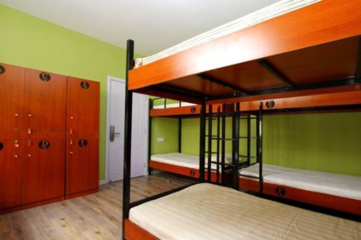Une chambre avec des lits superposés en bois, une armoire et une porte.