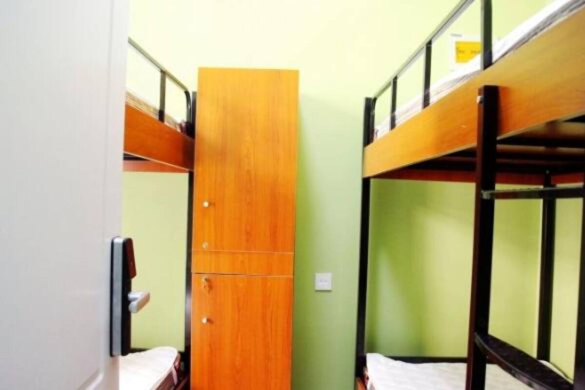 Une chambre avec un lit superposé, une armoire en bois et une porte.