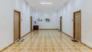Un pasillo con piso estampado, puertas de madera y una obra de arte colgada en la pared.