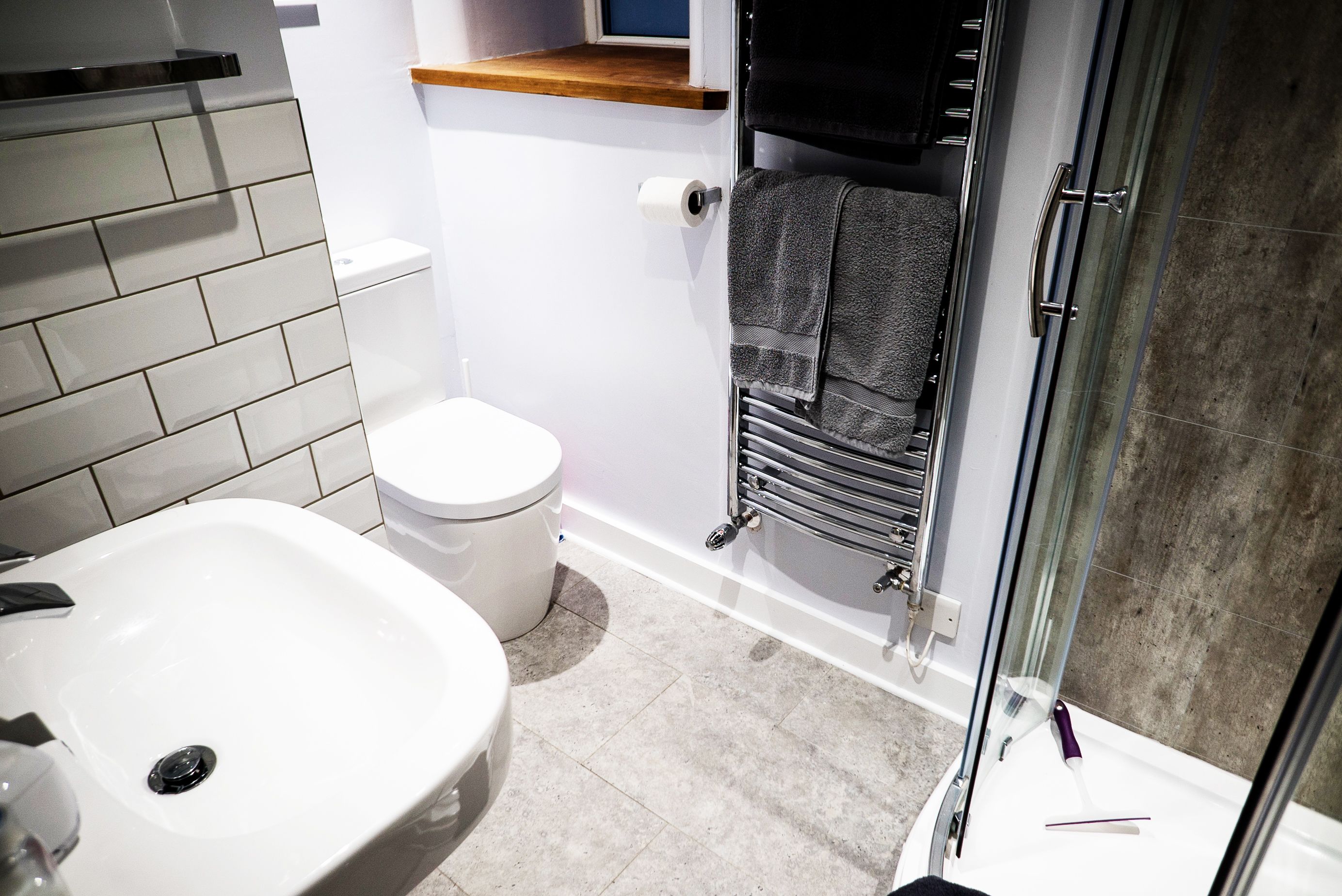 Un baño con lavamanos blanco, inodoro y cabina de ducha de vidrio.
