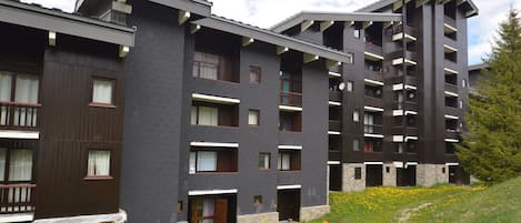 Un hotel de varios pisos con diseño moderno, que cuenta con balcones y fachada de piedra.