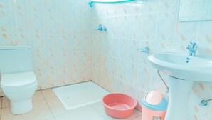 Een badkamer met toilet, wastafel en douchehoek.