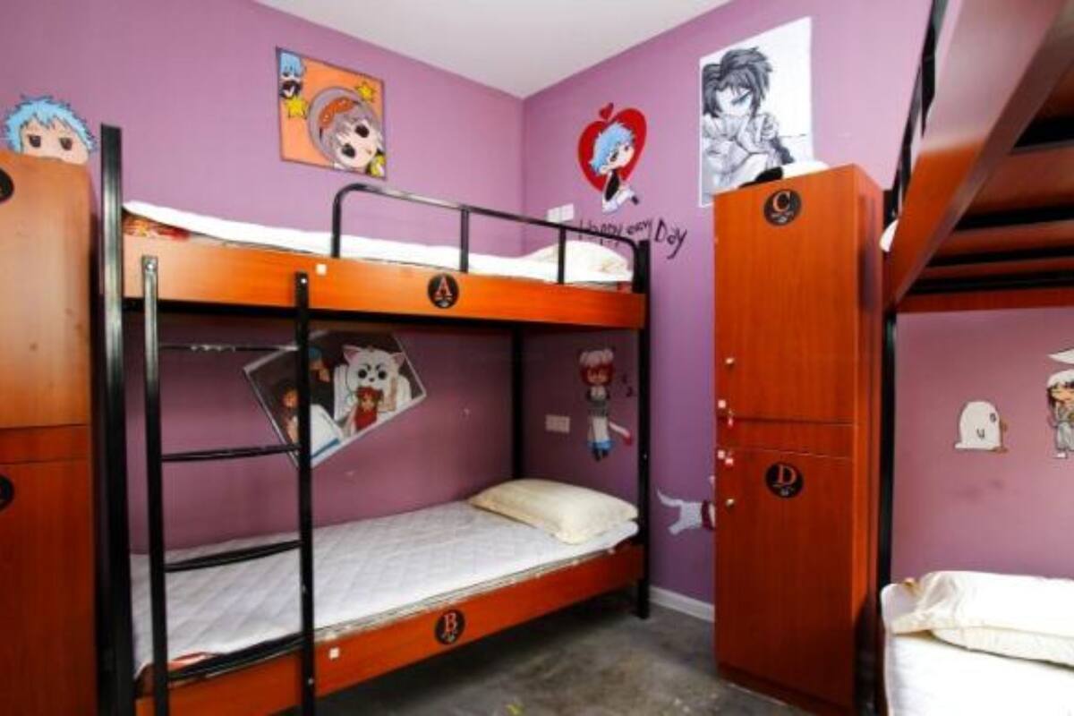 Ein Schlafraum mit Etagenbetten, einer violetten Wand, einem Poster mit einer Zeichentrickfigur und einer Tür mit einem Logo.