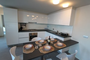 Apartamento superluxo, 1 quarto | Cozinha privada | Geladeira, micro-ondas, fogão, cooktop