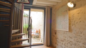 Una escalera con un cartel de seguridad, un mapa en la pared y vistas a un área exterior con una mesa y sillas.