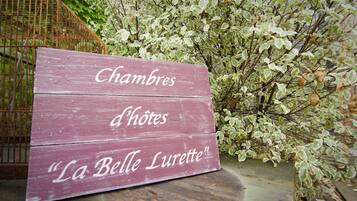 Un letrero de madera con el texto 'Chambres d'hôtes 'La Belle Lurette'.