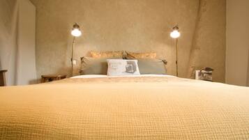A bedroom with a large bed, two bedside lamps, and a pillow with a photo.