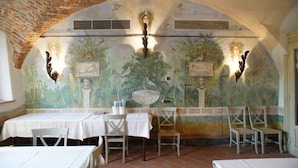 A dining area with tables and chairs, a mural with floral and bird designs, and a brick ceiling. - Corte Breda Agriturismo Bed & Breakfast (Chiari)