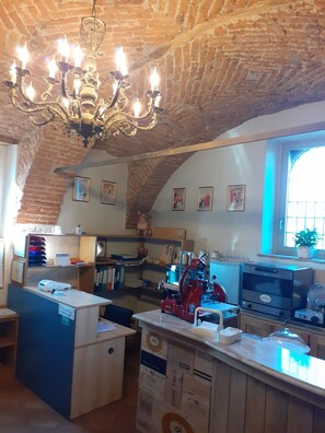 A kitchen with a brick ceiling, a chandelier, and various appliances including a red coffee machine. - Corte Breda Agriturismo Bed & Breakfast (Chiari)