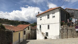 Una calle estrecha con adoquines, un hidrante rojo y edificios con tejados de tejas.