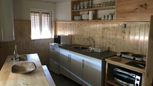 Una cocina compacta con gabinetes de madera, un lavamanos, una estufa y un tostador.