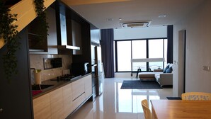 A modern kitchen with a wooden countertop, stainless steel appliances, and a large window. - Casa Duplex at Sunrise Gurney Seaview (George Town)