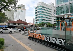 A modern building with a large sign reading "Sunrise@Gurney."