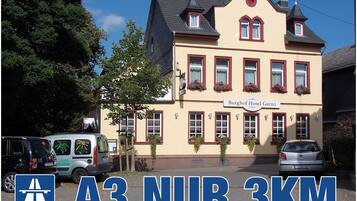 A traditional building with a sign reading "Burghof Hotel Garni."