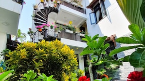 A residential building with balconies adorned with potted plants and flowers. - Anh Family Homestay (Da Nang)