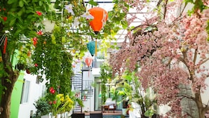 An indoor garden with hanging lanterns, a pool, and various plants. - Anh Family Homestay (Da Nang)