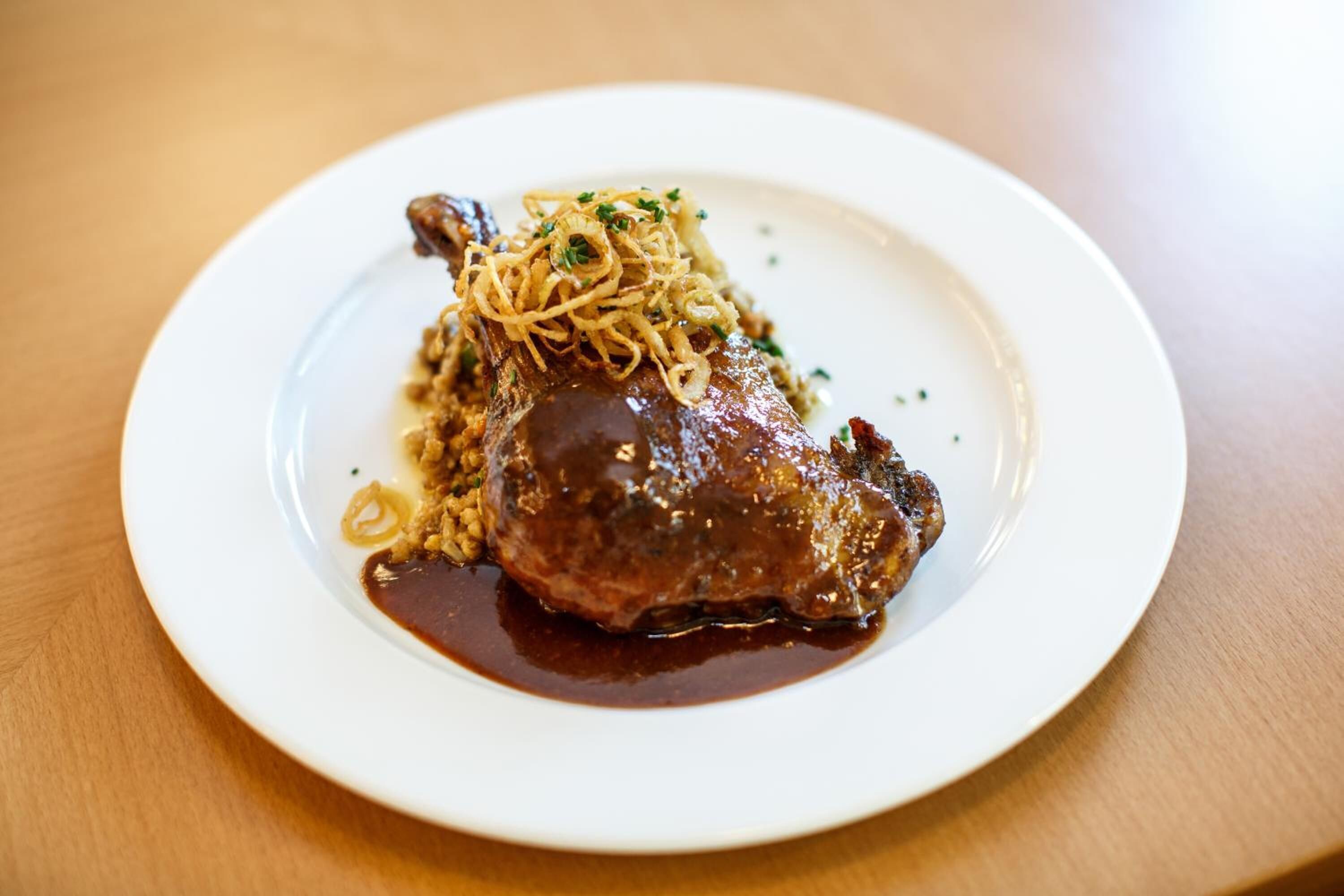 A plate with a piece of meat and noodles.