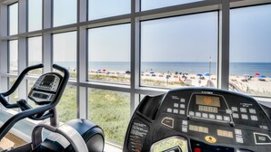 A gym with a view of the beach through large windows. - Crystal Shores 1104 2 Bedroom Condo by RedAwning (Gulf Shores)