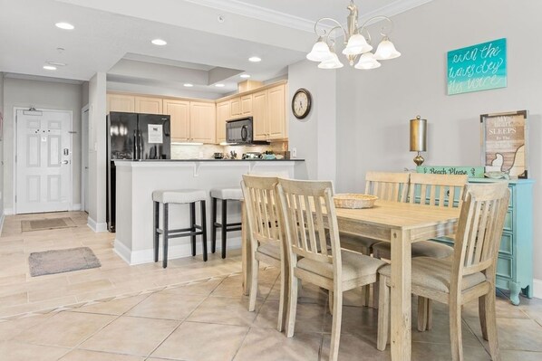 Una cocina moderna con una isla central, sillas de madera y una mesa de comedor.