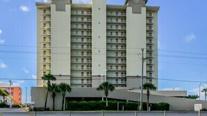 A multi-story hotel with a symmetrical facade, multiple balconies, and a central entrance. - Crystal Shores 1104 2 Bedroom Condo by RedAwning (Gulf Shores)