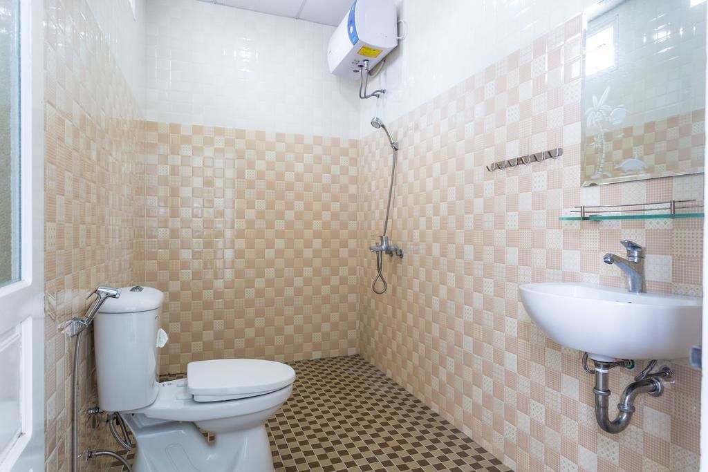 A bathroom with a toilet, a shower, and a sink.
