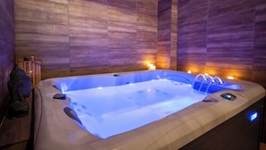 Un jacuzzi con panel de control, rodeado de paneles de madera y una estatua.