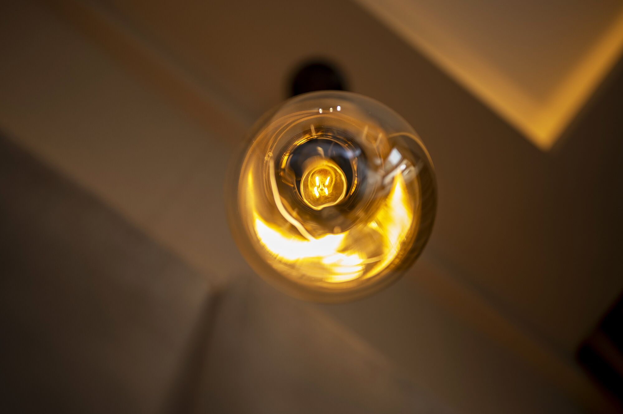Close-up van een gloeilamp met zichtbaar gloeidraad en glazen structuur.