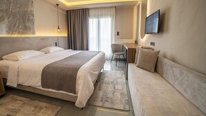 Una habitación de hotel moderna con una cama grande, un sofá, un escritorio y un televisor.