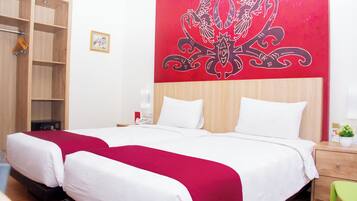Habitación de hotel con una cama grande, un armario de madera y una pared roja con un diseño decorativo.