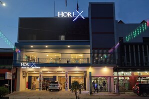 A hotel named HOREX with a modern facade, a visible entrance, and a balcony area.