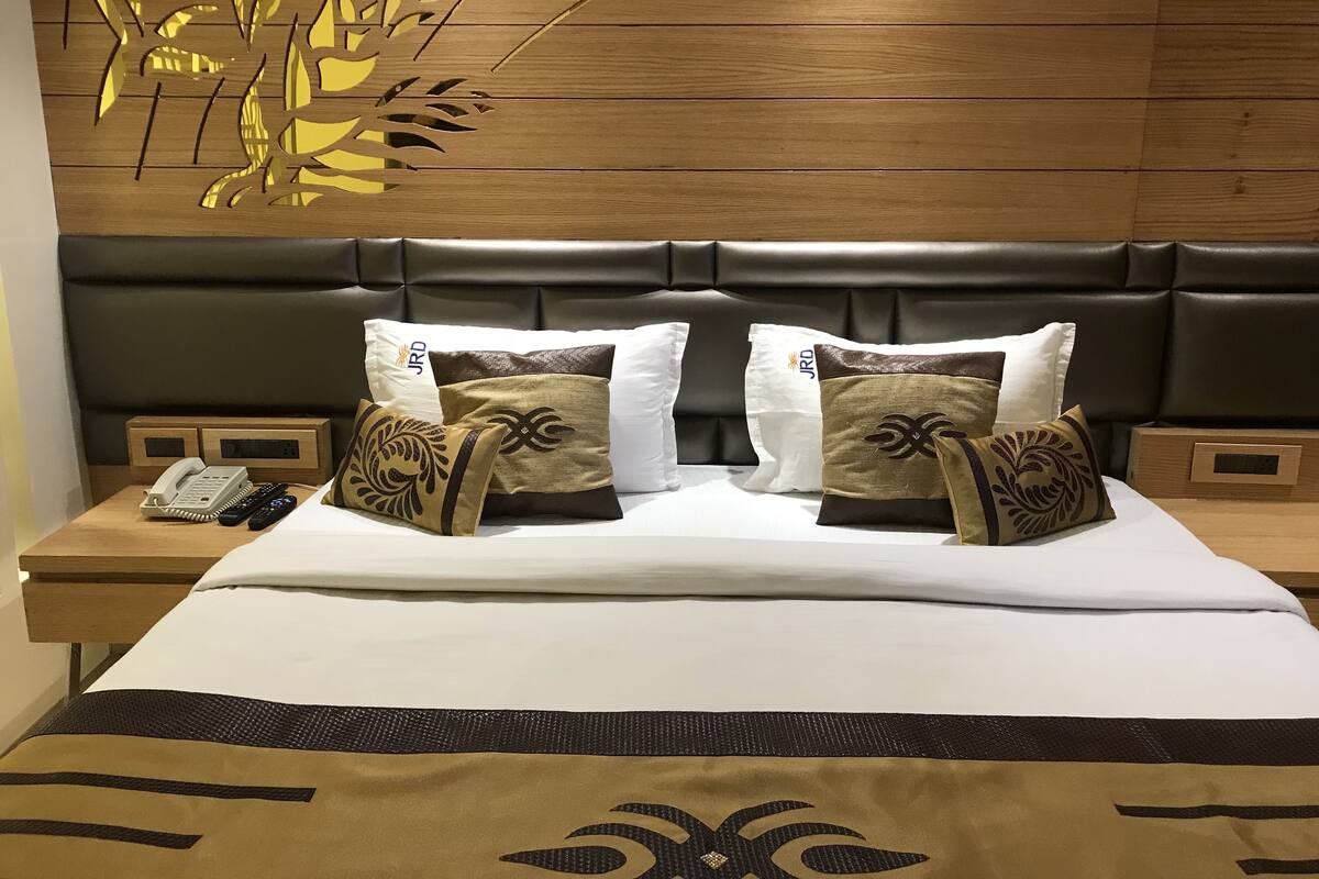 Ein Hotelzimmer mit einem Bett, zwei Nachttischen, einem Telefon und dekorativen Kissen.