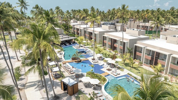 A resort with multiple swimming pools, palm trees, and modern buildings.