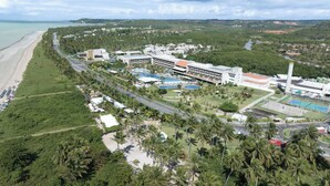 A resort with a beach, swimming pools, and a tennis court.