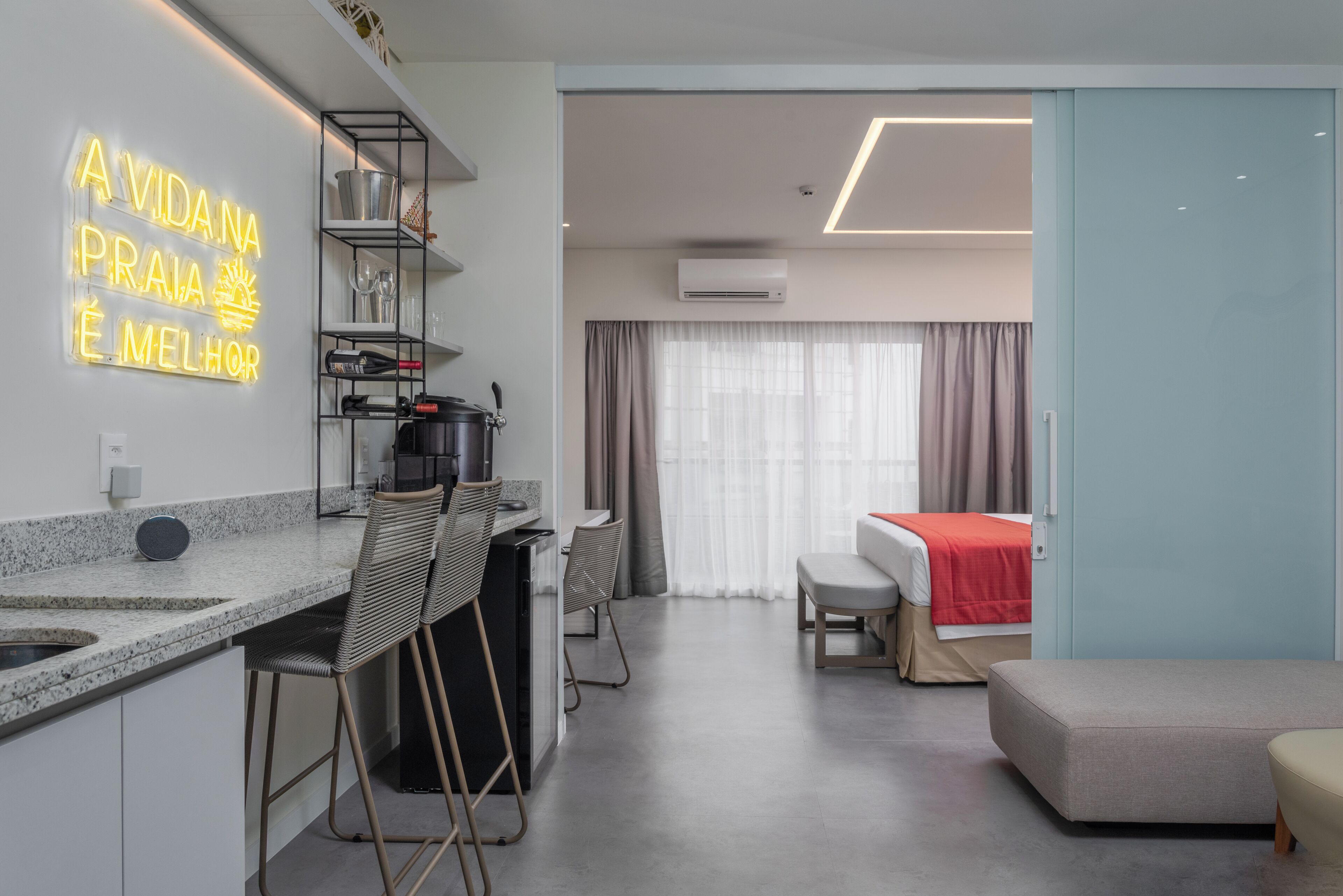Habitación de hotel moderna con cocina, mesa de comedor y cama.