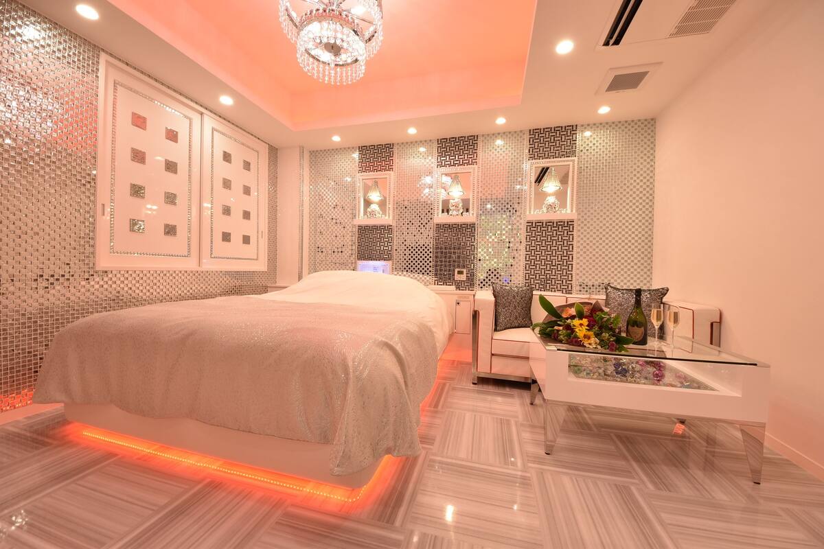 Une chambre moderne avec un grand lit, une table basse en verre et des panneaux décoratifs sur les murs.