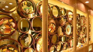 A wall of round mirrors displaying various food items. - Hotel SARA Kawagoe - Adults Only (Kawagoe)